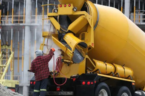 Hombre limpiando una hormigonera en una obra con agua cuyo pH se regula mediante inyección de CO₂ (Nexelia™)