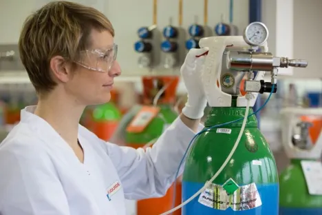 Técnica de laboratorio manipulando una botella ALPHAGAZ™ 2 de argón